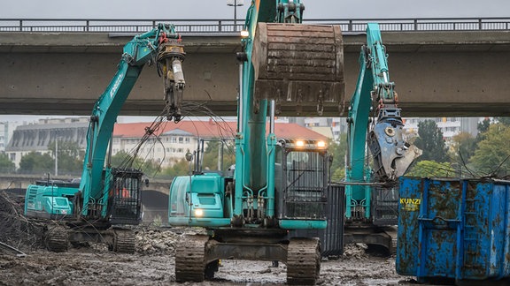 Mit Baggern werden weitere Teile der eingestürzten Carolabrücke abgerissen. 