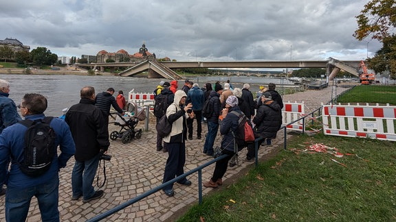 Schaulustige schauen auf die teilweise eingestürzte Carolabrücke in Dresden. 