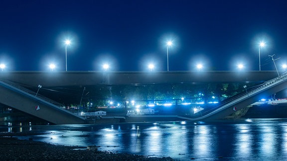 Blick auf die teilweise eingestürzte Carolabrücke bei Nacht. 