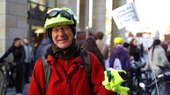 Ein Man mit Fahrradhelm schaut freundlich in die Kamera