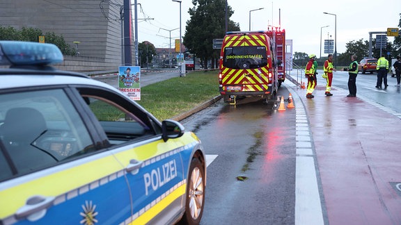 Einsatzkräfte von Feuerwehr und Polizei befinden sich auf der Altstadtseite der Carolabrücke.