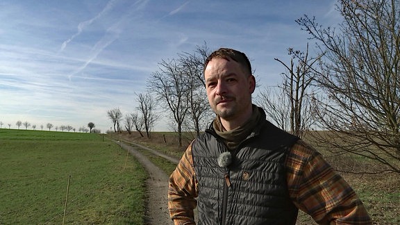 Ein Jäger steht an einem Feld bei Dresden.