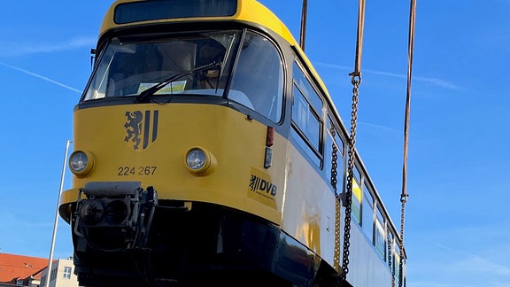 Tatra-Bahn hängt an einem Kran.