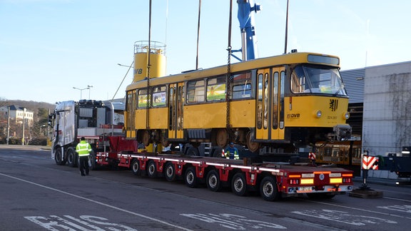 Straßenbahn steht auf einem Tieflader.