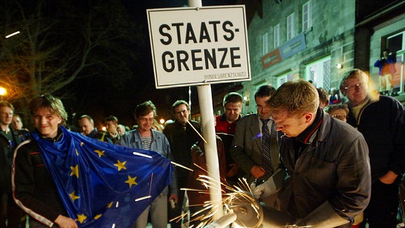 Ein Arbeiter entfernt die Überreste eines eisernen Grenzzauns aus der Zeit des Kalten Krieges an der deutsch-tschechischen Grenze in Bayerisch Eisenstein, 2004