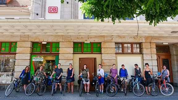 Gruppenbild von Radlerinnen vor einem Bahnhofsgebäude