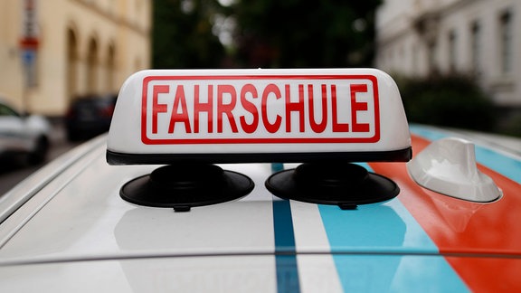 Ein Schild Fahrschule auf einem Fahrschul-Auto 