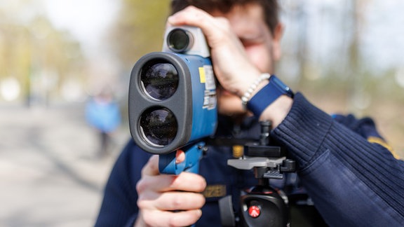 Ein Polizist schaut während des sogenannten Blitzmarathons durch ein Laserhandmessgerät (Laserpistole) des Typs LTI 2020 Truespeed.