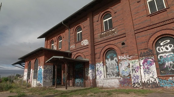 Ein Bahnhofsgebäude mit Graffitis bemalt