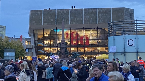 Auf dem Augustusplatz stehen viuele Menschen und warten, dass das Lichtfest 2024 beginnt.