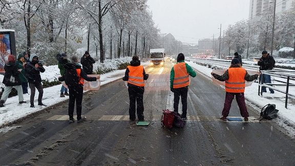 Klimaschützer stehen auf dem Georgiring in Leipzig