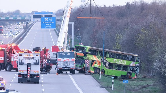 Ein verunglückter Reisebus wird an der Unfallstelle auf der A9 von einem Kran geborgen