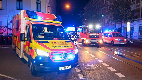 Einsatzwagen stehen auf einer Straße in Leipzig.