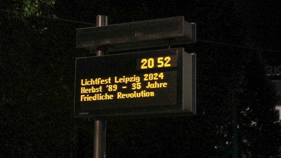 Auf einer elektronischen Fahrgast-Informationstafel der Leipziger Verkehrsbetriebe wird auf die Feierlichkeiten in der Stadt am 9.10.2024 hingewiesen.