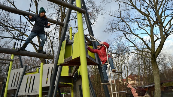 Oma mit Enkelinnen auf Spielplatz.