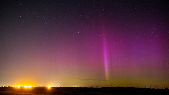 Polarlichter leuchten am Nachthimmel über Leipzig.