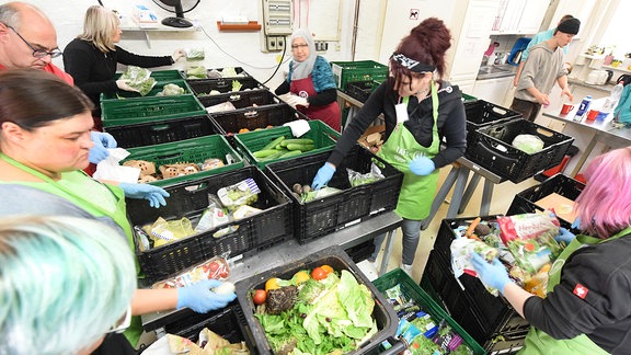 In einer Ausgabestelle der Leipziger Tafel e.V. sortieren Mitarbeiterinnen und Mitarbeiter gespendete Lebensmittel