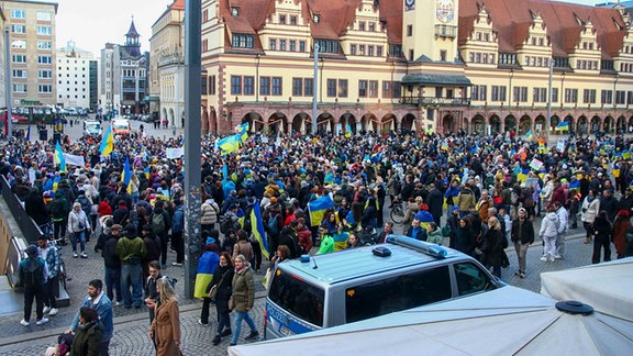 Menschen erinnern auf dem Leipziger Marktplatz an den russischen Überfall auf die Ukraine.