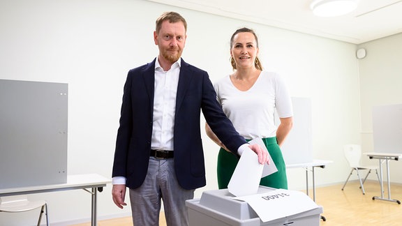 Michael Kretschmer (CDU), Ministerpräsident von Sachsen, steht mit seiner Frau Annett Hofmann bei der Stimmabgabe zur Landtagswahl in Sachsen im Wahllokal an einer Wahlurne.