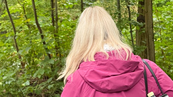 Eine Frau im Wald von hinten