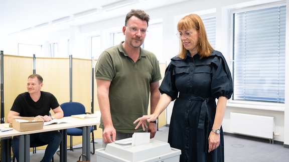 Katja Meier (Bündnis90/Die Grünen), Justizministerin von Sachsen, steht bei der Stimmabgabe zur Landtagswahl in Sachsen im Wahllokal neben Ingo Wobst, Wahlhelfer, an einer Wahlurne. In Sachsen findet am Sonntag die Landtagswahl statt.