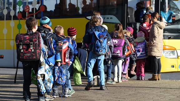 Schüler steigen in einen Schulbus