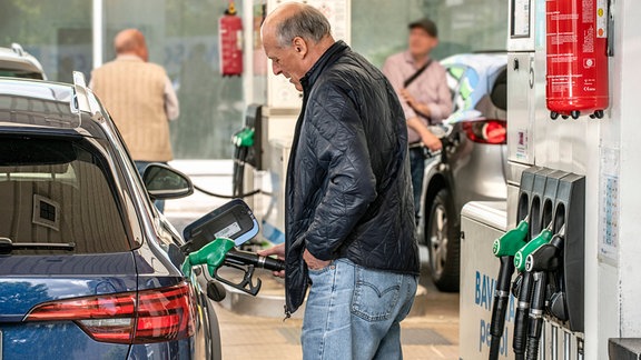 Ein Mann betankt sein Auto