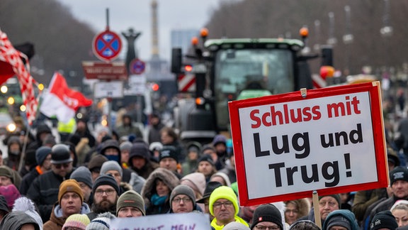 Teilnehmer der durch die Interessenvertretung „Freie Bauern“ angemeldeten Kundgebung stehen mit Schildern und Flaggen auf der Straße des 17. Juni vor dem Brandenburger Tor.