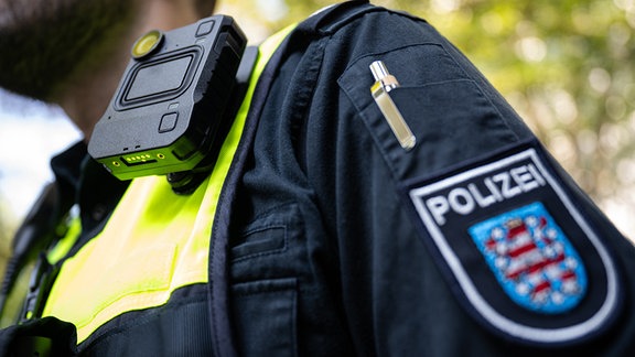 Ein Polizist trägt eine Bodycam an seiner Weste. 