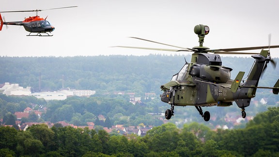 Ein Kampfhubschrauber vom Typ «Eurocopter Tiger» (rechts) startet auf dem Heeresflugplatz Bückeburg während ein Hubschrauber vom Typ «Bell 206B JetRanger III» (links) landet. 