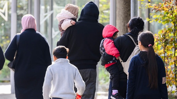 Flüchtlinge verlassen eine Unterkunft.