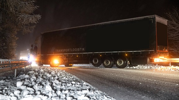 Bei Winterwetter und Glätte hat sich ein Lkw auf der Straße quer gestellt