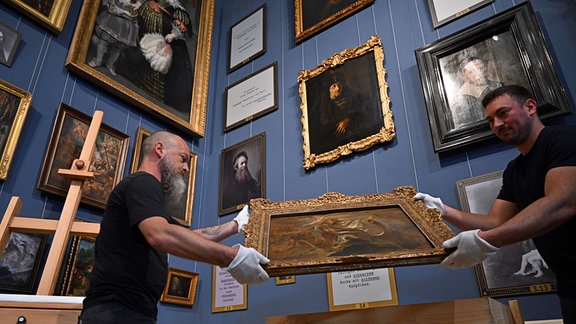 Zwei Depotmitarbeiter mit weißen Handschuhen stellen die Ölskizze «Der Heilige Gregorius von Nazianz» von Peter Paul Rubens aus dem Jahr 1621 im Herzoglichen Museum der Friedenstein Stiftung Gotha auf.