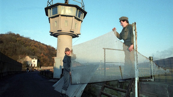 Am Grenzübergang Philippsthal (Hessen) - Vacha (Kreis Hersfeld - Rothenburg) haben Grenzsoldaten am 28.11.1989 damit begonnen, einen 150 Meter langen Metallgitterzaun zwischen Hessen und Thüringen zu demontieren