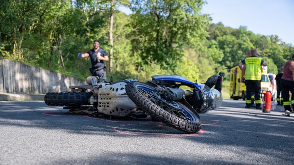 Ein kaputtes Motorrad liegt auf der Straße.