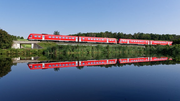 Ein rot lackierter Nahverkehrszug auf einer Strecke ohne elektrische Oberleitung.