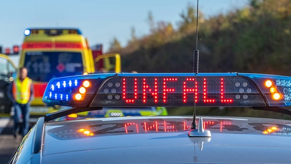 Ein Einsatzfahrzeug der Polizei mit Blaulicht bei einem Unfall.