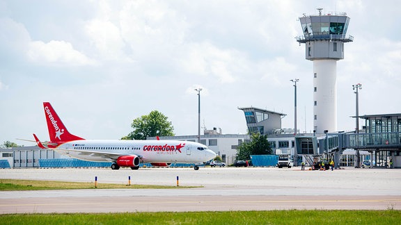 Ein Flugzeug rollt auf der Landebahn des Flughafengeländes.