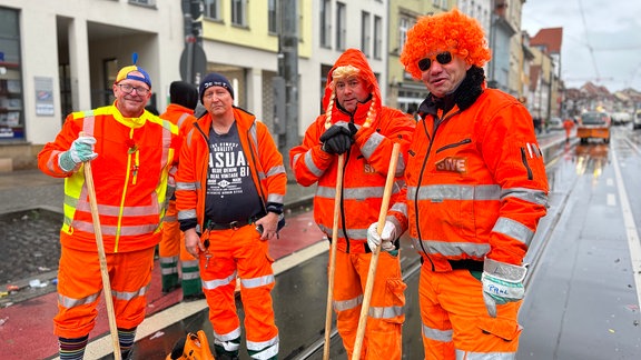 Vier verkleidete Müllmänner auf der Straße.