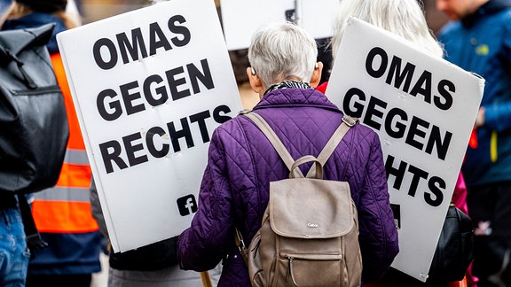 Erfurt: Eine Demonstrantin von Omas gegen Rechts mit Schildern.