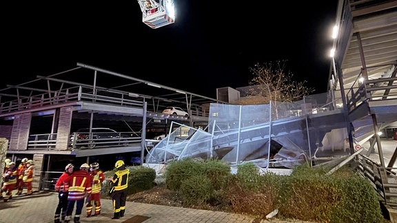 Feuerwehrleute neben einer eingestürzten Parkhaus-Rampe.