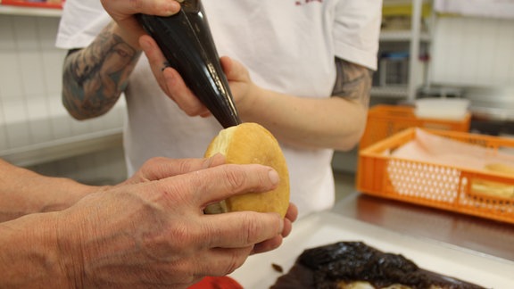 Bäckerei Bergmann in Frömmstedt. Die Herstellung einer Füllung aus Vita-Cola für Pfannkuchen, das Füllen der Pfannkuchen und das Glasieren.