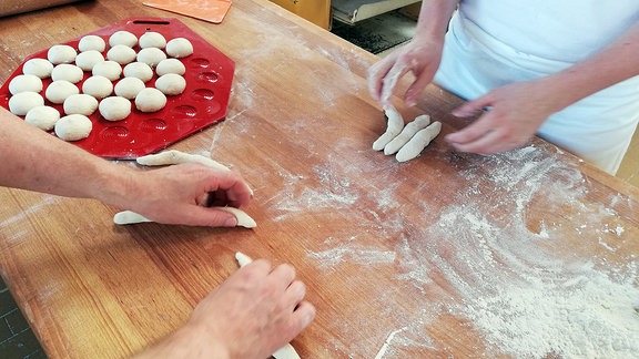 In einer Bäckerei werden verschiedene Backwaren geformt.