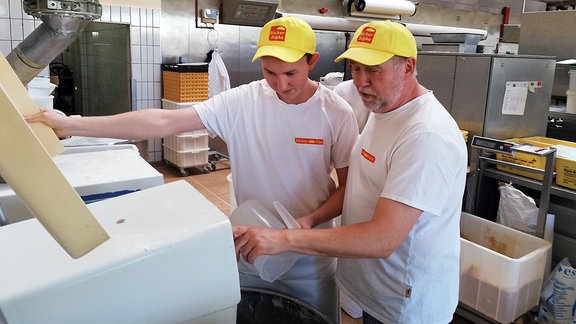 Zwei Männer an einer Maschine in einer Bäckerei