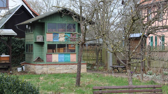 Ein buntes Häuschen steht in einem Garten.