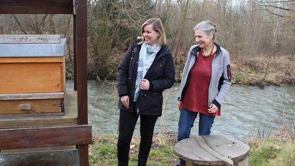 Zwei Frauen stehen nebeneinander und lachen.