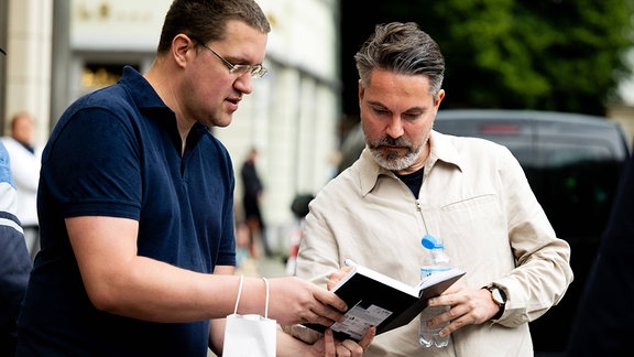 Der Spitzenkandidat des Bündnis Sahra Wagenknecht zur Europawahl 2024, Fabio De Masi, gibt einem Gast ein Autogramm. 