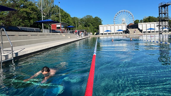 Badegäste schwimmen im Freibad