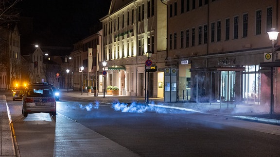 Silvester-Feuerwerk explodiert vor Polizeiautos.