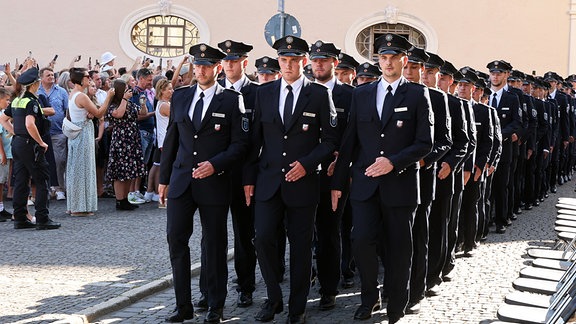 Thüringer Polizistinnen und Polizisten marschieren zu ihrer Vereidigung auf dem Platz der Demokratie. 